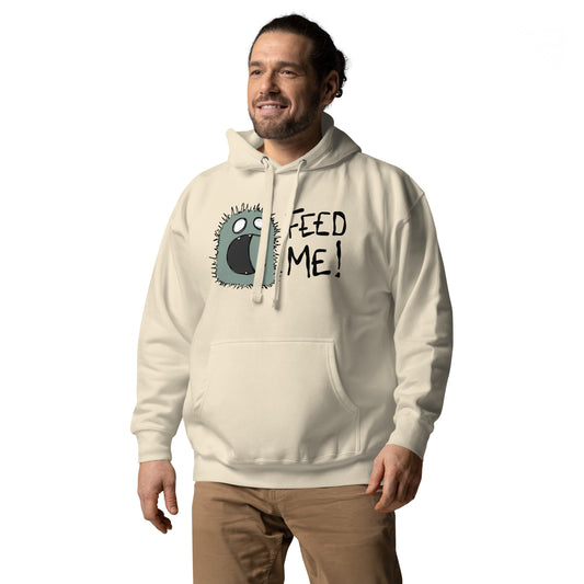 Man wearing a cream hoodie with a monster character design and text FEED ME on a white background