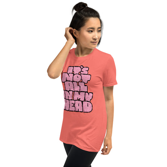 Person wearing a pink t-shirt with text IT'S NOT ALL IN MY HEAD on a white background