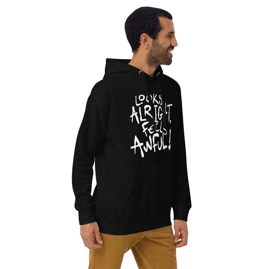 Man wearing a black hoodie with white text LOOKS ALRIGHT FEELS AWFUL on a white background