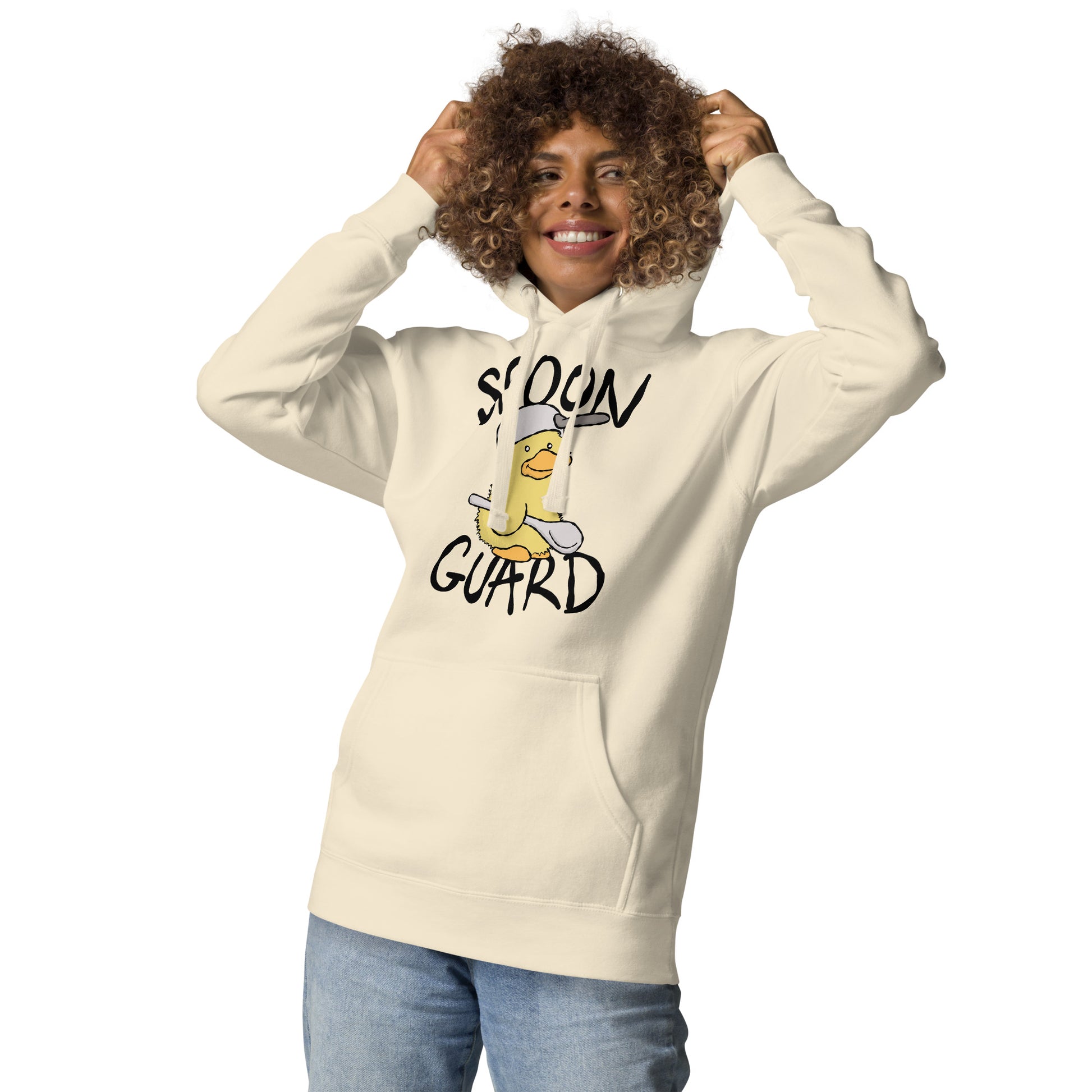 Person wearing a cream hoodie with a graphic design and text on a white background