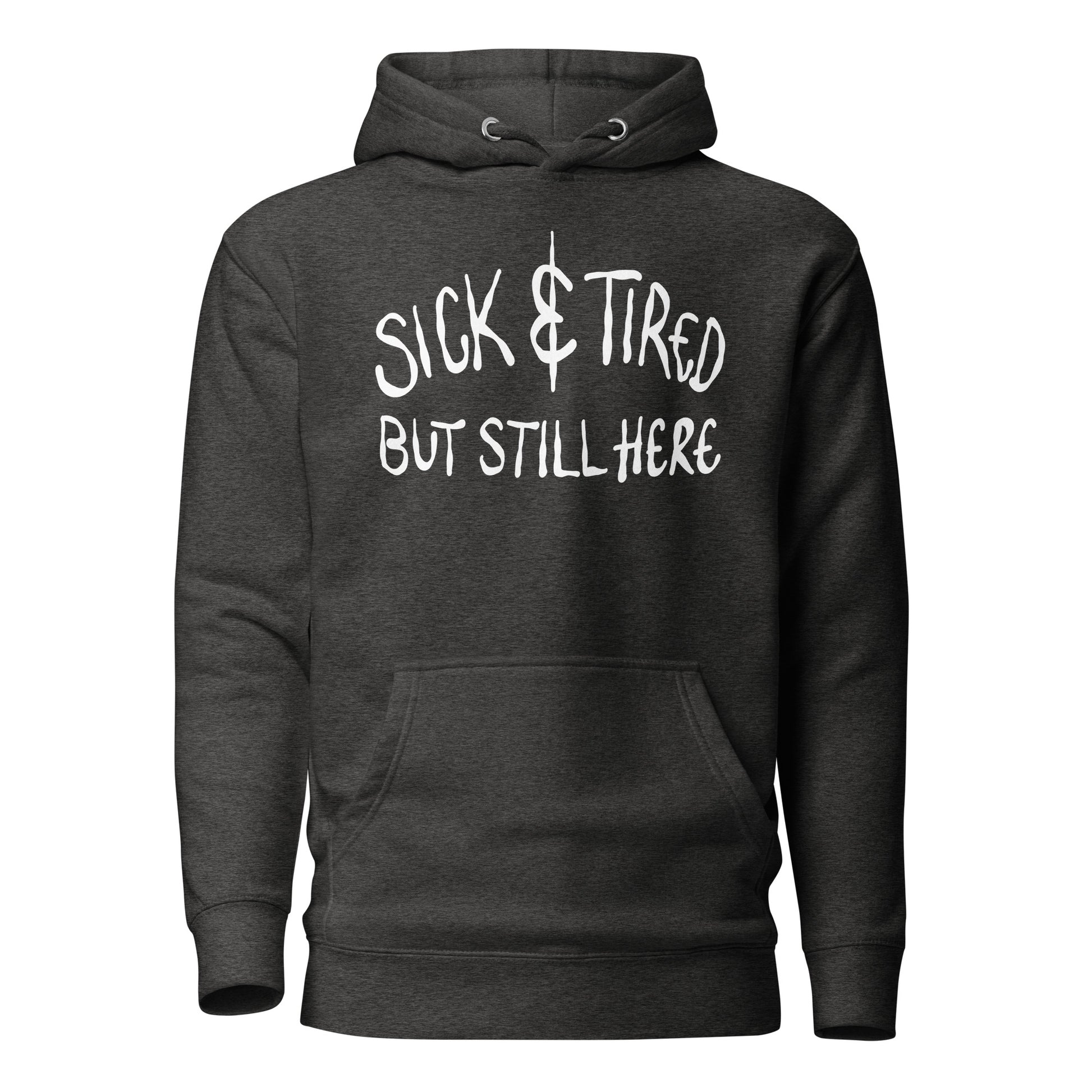 Black hoodie with white text 'SICK & TIRED BUT STILL HERE' on a white background